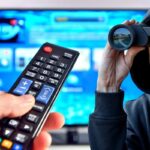 Telecomando puntato verso la tv, ragazzo con il binocolo