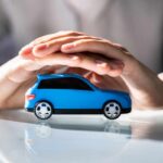 Persona che tiene tra le mani un automobile blu