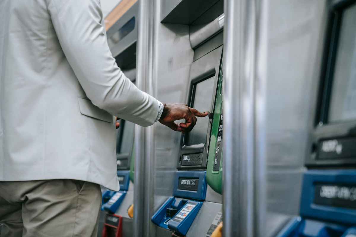 Persona preleva i soldi al bancomat