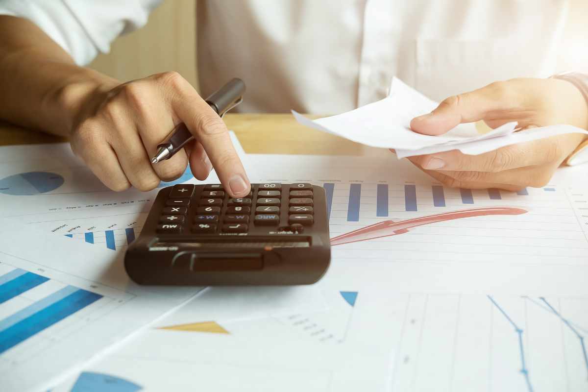 Persona fa i calcoli con la calcolatrice