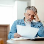 Uomo preoccupato mentre legge un documento