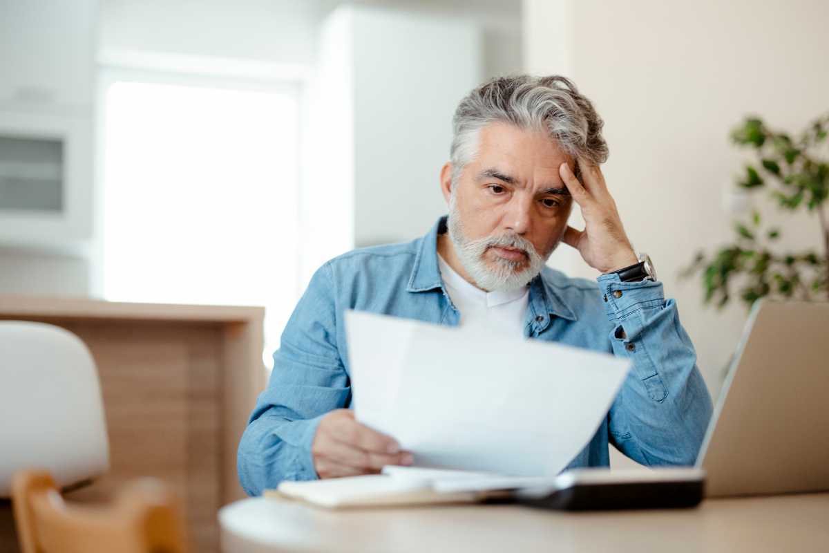 Uomo preoccupato mentre legge un documento