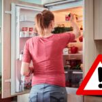 Donna di spalle che apre il frigorifero