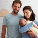 mamma e papà con un neonato in braccio