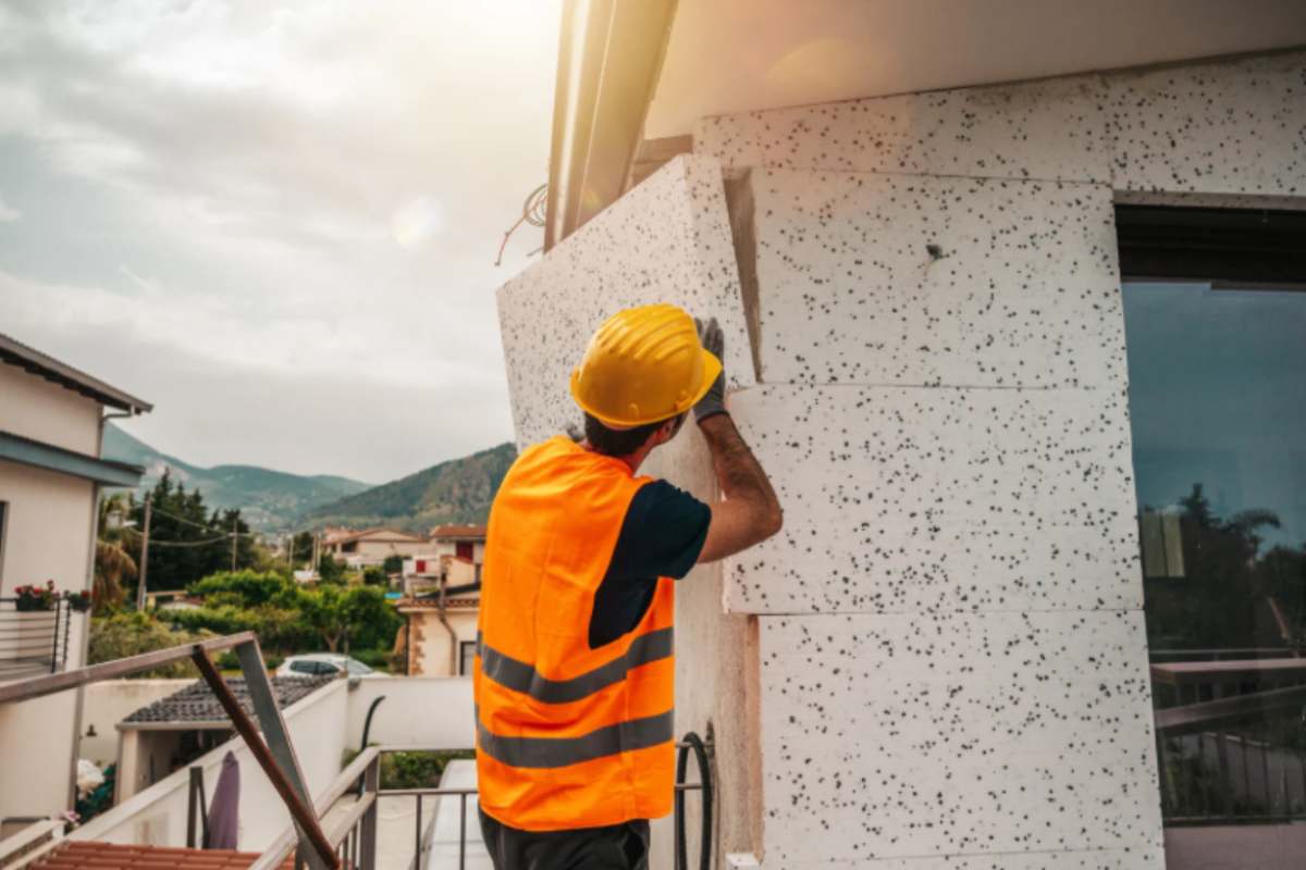 operai che installa il cappotto termico all'esterno dell'edificio