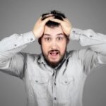 uomo preoccupato con le mani nei capelli