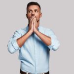 uomo preoccupato con le mani davanti alla bocca