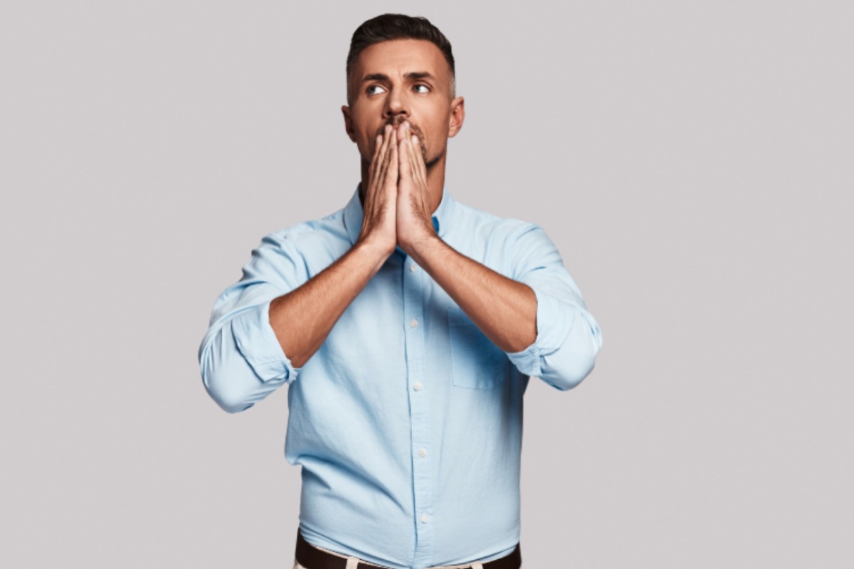 uomo preoccupato con le mani davanti alla bocca