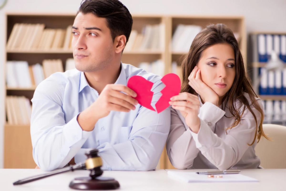 uomo e donna ciascuno con in mano metà cuore spezzato e davanti il martelletto di un giudice
