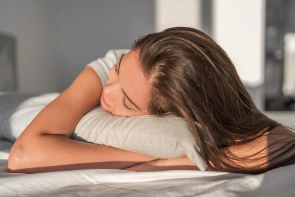 donna che dorme a pancia in giù con le mani sotto al cuscino