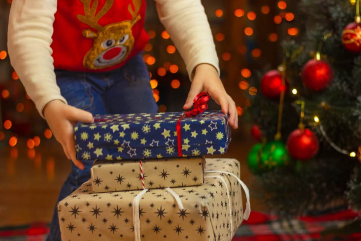 bambino che prende i pacchi dei regali di Natale