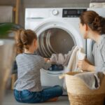 mamma e bambina che mettono il bucato nella lavatrice