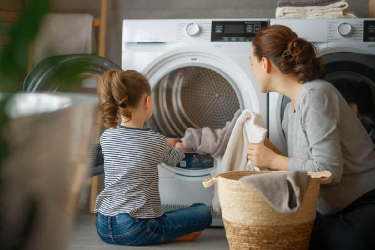 mamma e bambina che mettono il bucato nella lavatrice