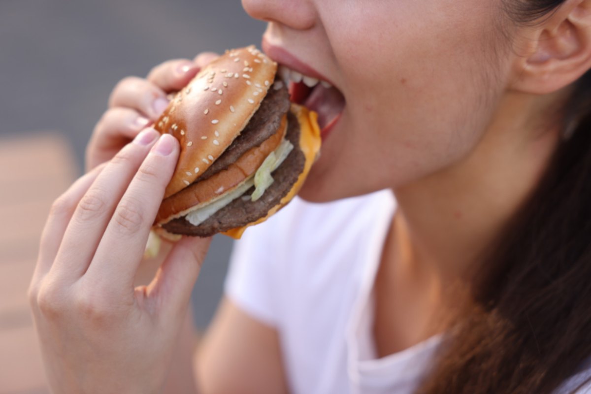 donna che mangia un hamburger