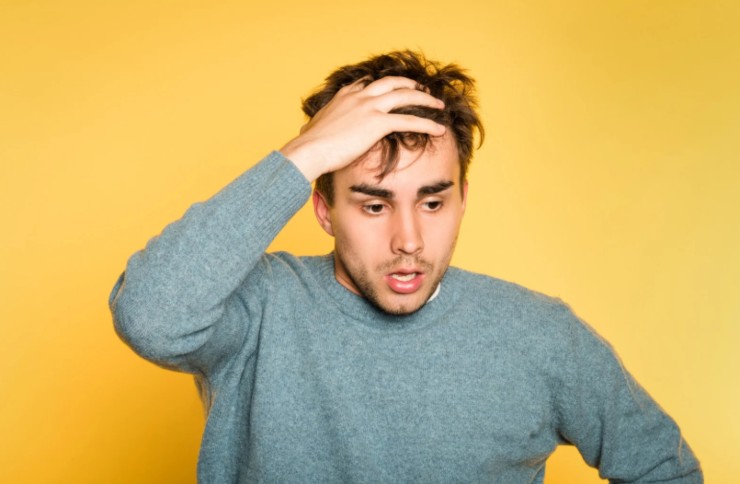 uomo preoccupato con una mano nei capelli