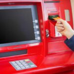 Persona inserisce la chiave nel bancomat