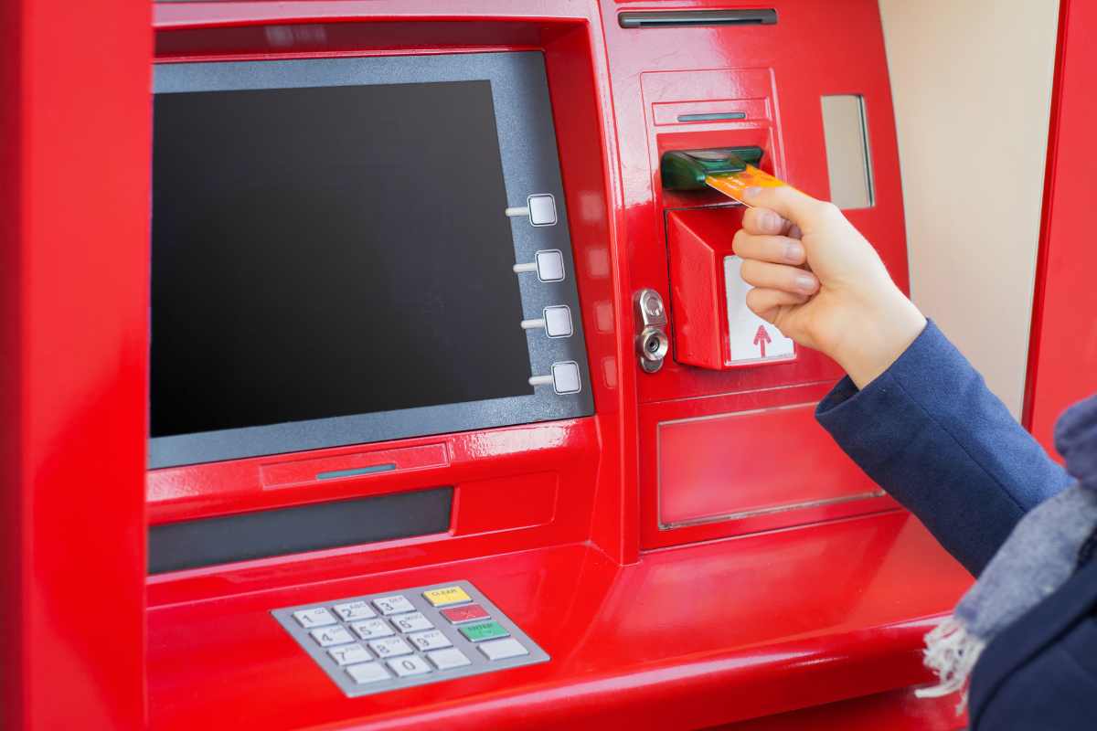 Persona inserisce la chiave nel bancomat