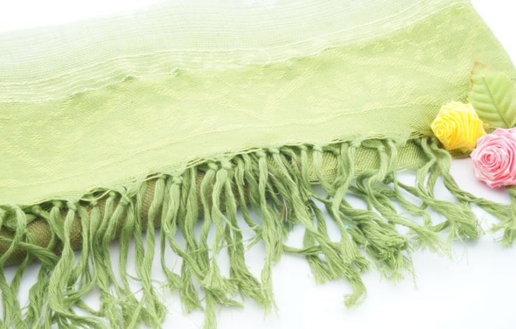sciarpa verde con accanto dei fiori