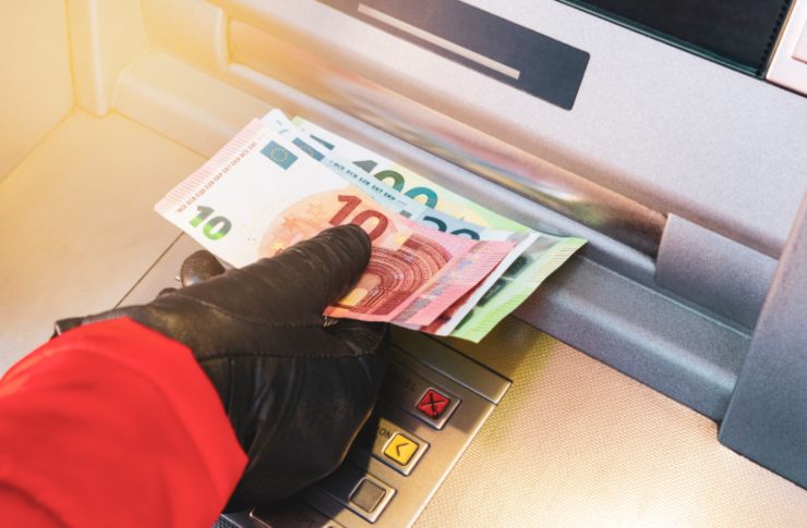 persona che ritira delle banconote dallo sportello automatico