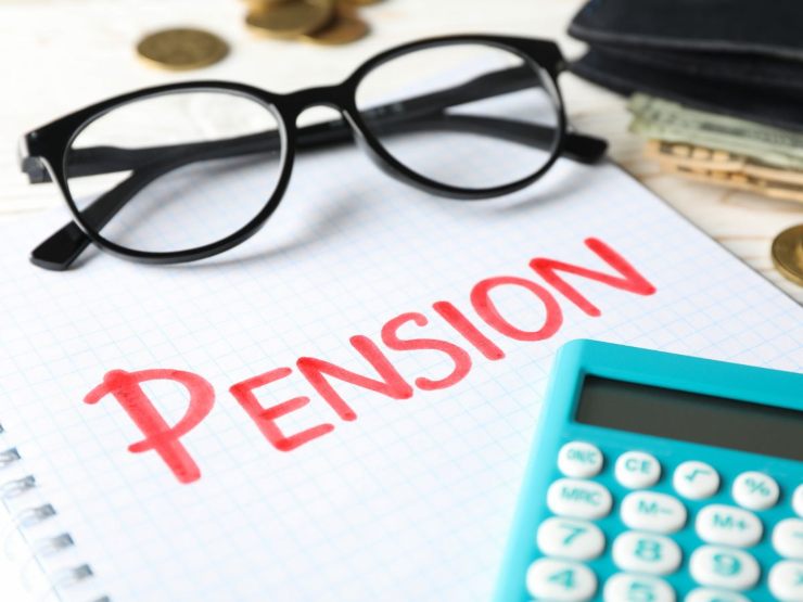 occhiali e calcolatrice su un foglio dove c'è scritto pension