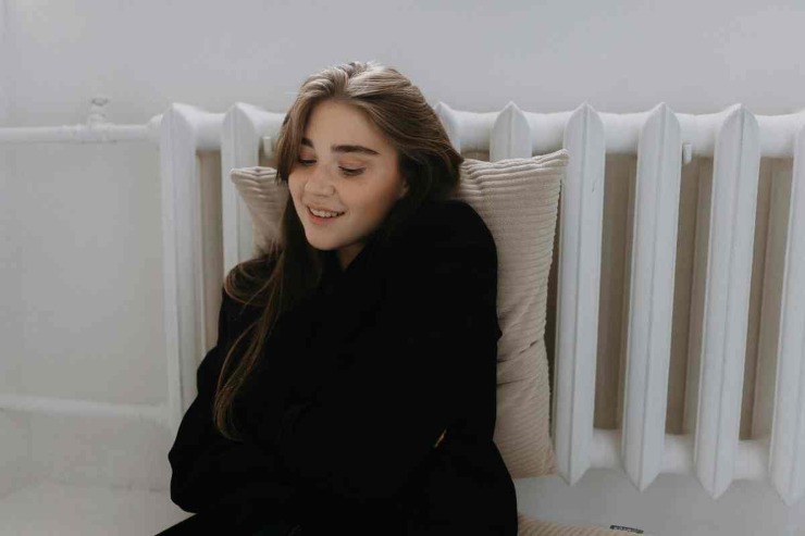 Ragazza appoggiata al termosifone