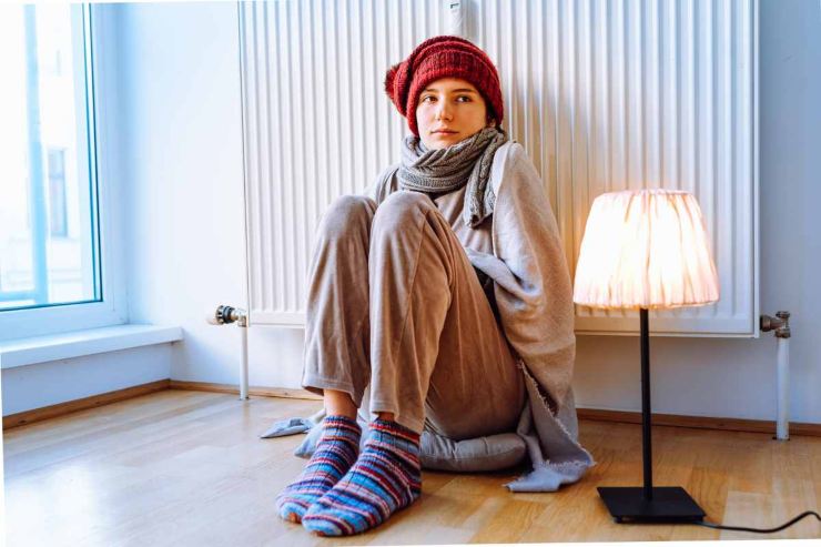 Donna appoggiata al termosifone