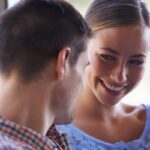 donna che sorride seduta accanto ad un uomo