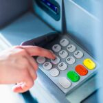 Persosna che digita sul bancomat