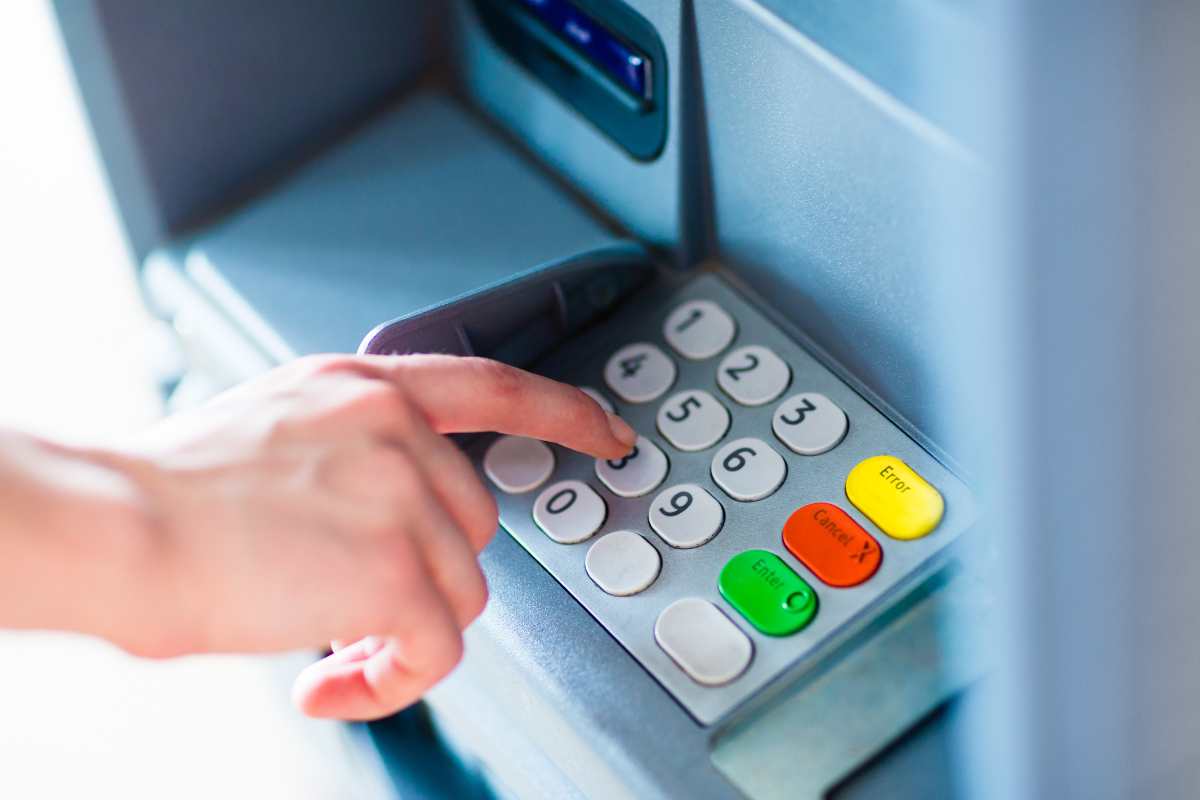 Persosna che digita sul bancomat